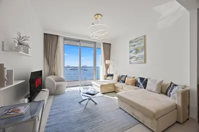 a living room with a couch and a tv at YOUR STAY APARTMENTS Luxury Beachfront Living in Dubai