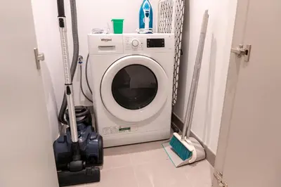 a washing machine in a room with a vacuum at YOUR STAY APARTMENTS Luxury Beachfront Living in Dubai
