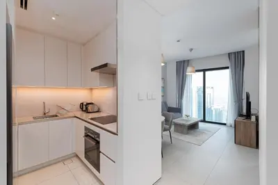 a kitchen with white cabinets and a living room at Address JBR Marina View, Jumeirah Beach Residence, Dubai Marina - Mint Stay in Dubai