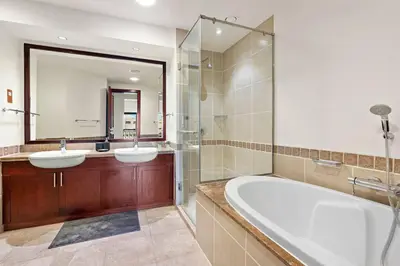 a bathroom with two sinks and a tub and a mirror at StoneTree - Luxurious 1BR with Beach Access in Dubai