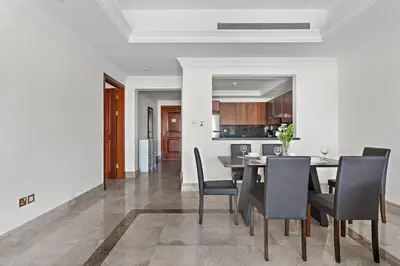 a dining room and kitchen with a table and chairs at StoneTree - Luxurious 1BR with Beach Access in Dubai
