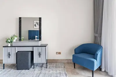 a room with a blue chair and a mirror at StoneTree - Luxurious 1BR with Beach Access in Dubai