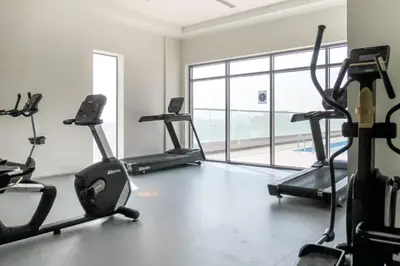 a gym with cardio machines and a large window at Frank Porter - Genesis by Meraki in Dubai
