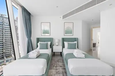 two beds in a room with two windows at StoneTree - Panoramic View - Spacious 2BR in Dubai