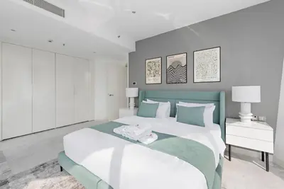 a white and green bedroom with a large bed at StoneTree - Panoramic View - Spacious 2BR in Dubai
