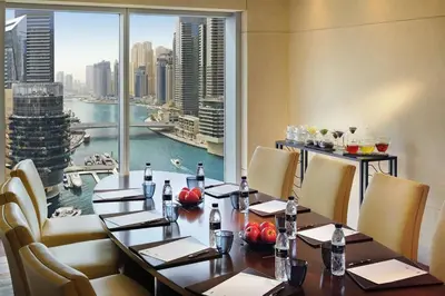 a restaurant with a table with chairs and a large window at Emaar Marina Residences - formerly Address Dubai Marina in Dubai