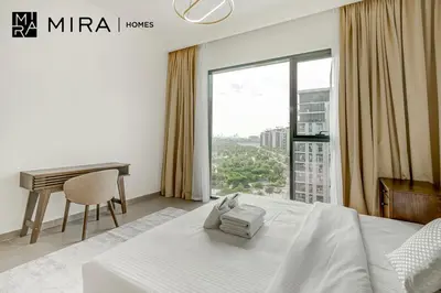 a bedroom with a bed and a desk and a window at Mira Holiday Homes - Fully furnished 2 bedroom in Dubai Hills in Dubai