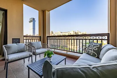 a balcony with couches and a view of a city at Apartment in Fairmont South Residence Palm Jumeirah in Dubai