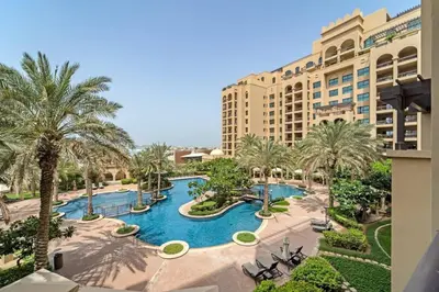 an aerial view of a resort with a pool and palm trees at Apartment in Fairmont South Residence Palm Jumeirah in Dubai