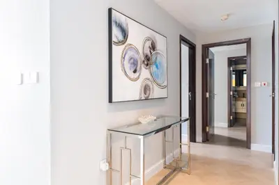 a room with a glass table and a painting on the wall at The Residences Towers - 3 Minute Walk to Dubai Fountain in Dubai