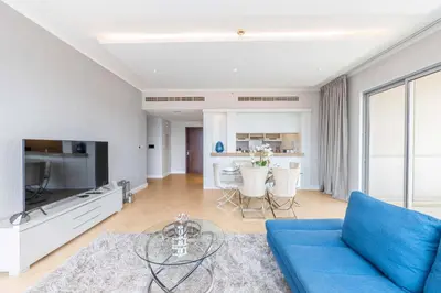 a living room with a blue couch and a table at The Residences Towers - 3 Minute Walk to Dubai Fountain in Dubai
