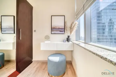 a room with a blue stool and a window at Gleeful 2BR at Sky Gardens DIFC by Deluxe Holiday Homes in Dubai