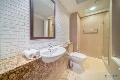 a bathroom with a sink and a toilet and a mirror at Gleeful 2BR at Sky Gardens DIFC by Deluxe Holiday Homes in Dubai