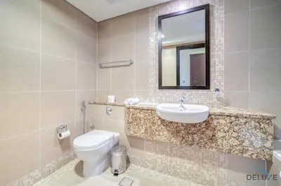 a bathroom with a toilet and a sink and a mirror at Amazing 2BR at Sky Gardens DIFC by Deluxe Holiday Homes in Dubai