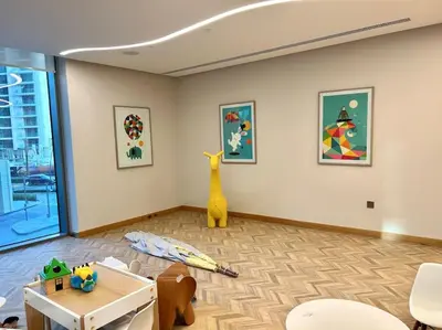 a room with a room with a table and paintings at Luxury Dubai Creek Balcony & View in Dubai