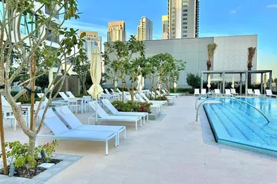 a pool with white lounge chairs and a swimming pool at Luxury Dubai Creek Balcony & View in Dubai