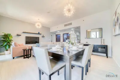 a dining room and living room with a table and chairs at Urbane 2BR At Shams 1 JBR by Deluxe Holiday Homes in Dubai