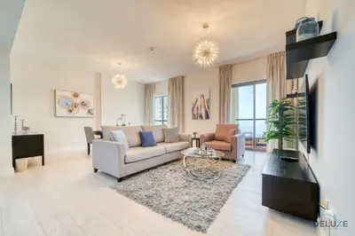 a living room with a couch and a tv at Urbane 2BR At Shams 1 JBR by Deluxe Holiday Homes in Dubai