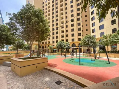 a playground in front of a large building at Urbane 2BR At Shams 1 JBR by Deluxe Holiday Homes in Dubai