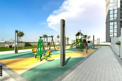 a playground with a slide and swings at Sleek One Bed Sobha Creek Vistas Reserve Tower A in Dubai