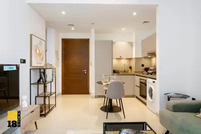 a living room with a couch and a kitchen at Sleek One Bed Sobha Creek Vistas Reserve Tower A in Dubai