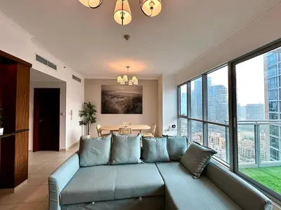 a living room with a blue couch and windows at Lux BnB I The Residences I Sky Line Views in Dubai