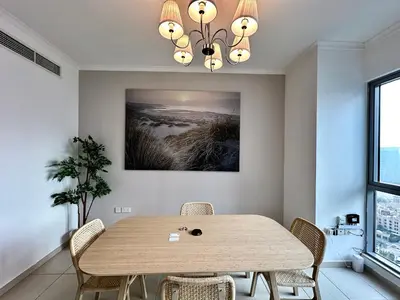 a dining room with a wooden table and chairs at Lux BnB I The Residences I Sky Line Views in Dubai