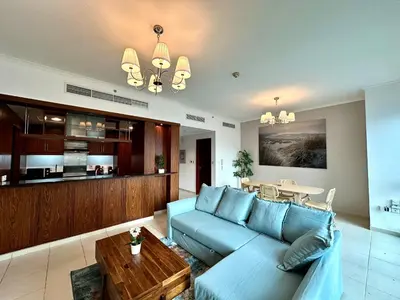 a living room with a blue couch and a table at Lux BnB I The Residences I Sky Line Views in Dubai