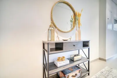 a console table with a mirror and a shelf at Dubai Elegance: 1BR with DIFC & Zabeel Views in Dubai