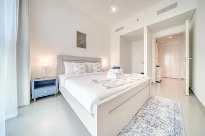 a white bedroom with a large bed and a mirror at Dubai Elegance: 1BR with DIFC & Zabeel Views in Dubai
