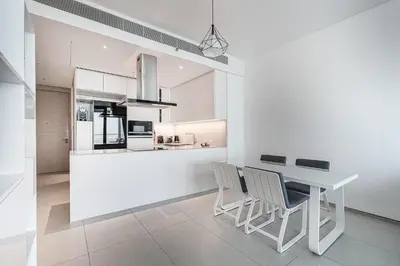 a kitchen and dining room with a white table and chairs at Manzil - 2BR Apartment in The Address JBR with Private Beach Access & Dubai Eye View in Dubai