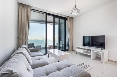 a living room with a couch and a tv at Manzil - 2BR Apartment in The Address JBR with Private Beach Access & Dubai Eye View in Dubai