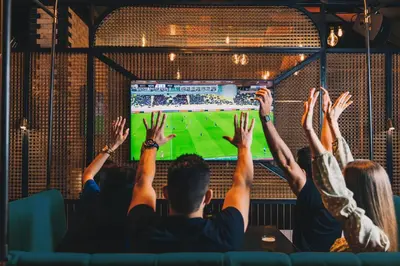 a group of people watching a soccer game on a television at FIVE LUXE in Dubai