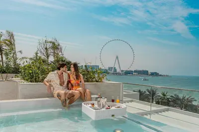 a man and a woman sitting in a swimming pool at FIVE LUXE in Dubai