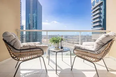 two chairs and a table on a balcony with a view at Frank Porter - Lake View Tower in Dubai