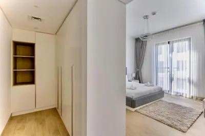 a white bedroom with a bed and a large window at Ocean Majestic Full Sea View at Le Pont in Dubai