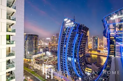 a tall blue building in a city at night at The Majestine Studio in Dubai