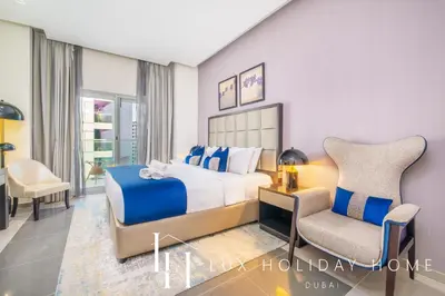 a hotel room with a bed and a chair at The Majestine Studio in Dubai