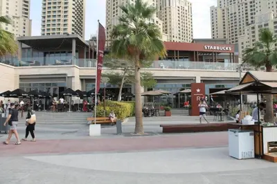a group of people walking in front of a building at Diamond Marina inn, Offers Spacious Apartment 5 min Walk To JBR Beach And METRO in Dubai