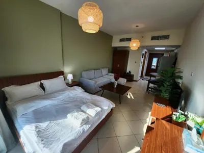 a bedroom with a bed and a living room at Diamond Marina inn, Offers Spacious Apartment 5 min Walk To JBR Beach And METRO in Dubai