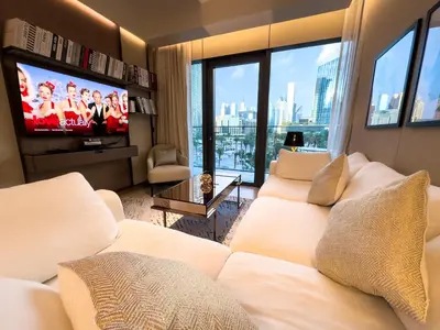 a living room with white couches and a flat screen tv at The Address Residences Dubai Opera, Full Burj Khalifa View, Luxurious 2BR in Dubai