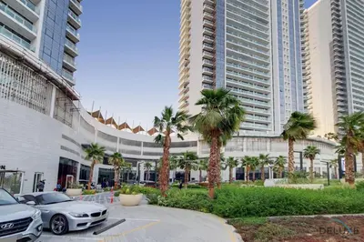 a parking lot with cars parked in front of a building at Appealing Studio at Carson C DAMAC Hills Dubailand by Deluxe Holiday Homes in Dubai