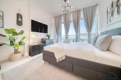 a bedroom with a large bed and a large window at Appealing Studio at Carson C DAMAC Hills Dubailand by Deluxe Holiday Homes in Dubai