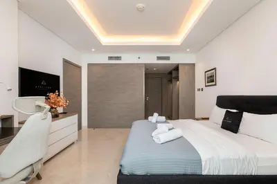 a bedroom with a large bed and a chair at Luxury 1BR Apartment with Burj Khalifa View at Sterling in Dubai