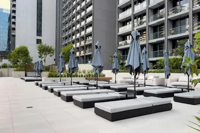 a row of tables with umbrellas in front of a building at Luxury 1BR Apartment with Burj Khalifa View at Sterling in Dubai