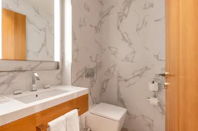 a white bathroom with a sink and a toilet at Address Dubai Opera Residences in Dubai