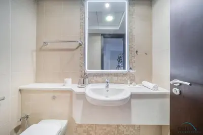 a bathroom with a sink and a mirror and a toilet at Limited Time Offer Stylish 1BR near to Metro by Deluxe Holiday Homes in Dubai