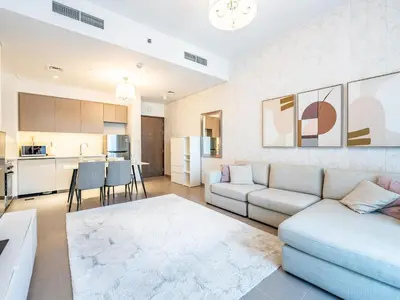 a living room with a couch and a kitchen at Modern 1BR in Park Heights 2, Dubai Hills in Dubai