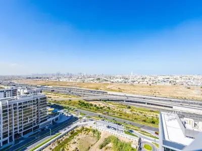 an aerial view of a city with a highway at Modern 1BR in Park Heights 2, Dubai Hills in Dubai