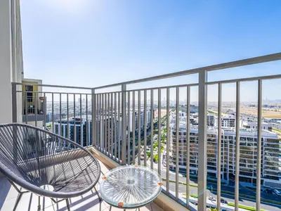 a balcony with a chair and a view of the city at Modern 1BR in Park Heights 2, Dubai Hills in Dubai